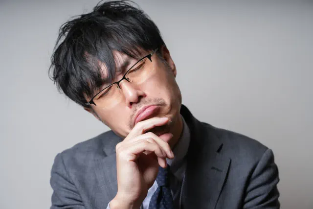 恥ずかしくて指差呼称できないことに悩む眼鏡のビジネスマン